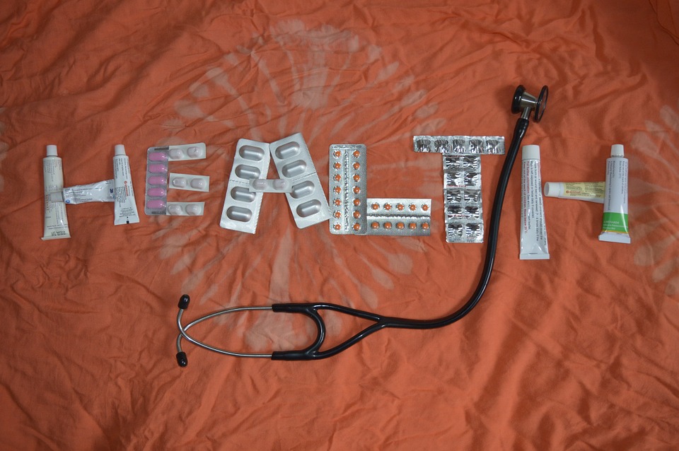The word health specialty out using packages of pills and a stethoscope, representing a medicare plan.
